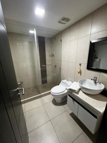 y baño con aseo, lavabo y ducha. en Cómoda suite en Puerto Santa Ana, en Guayaquil