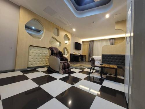 ein Zimmer mit einem karierten Boden und einem Zimmer mit einem Stuhl in der Unterkunft Bigbell House in Namyangju