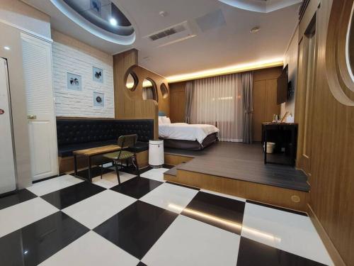 a hotel room with a bed and a checkerboard floor at Bigbell House in Namyangju