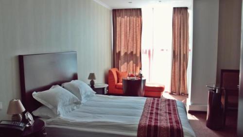 a hotel room with a bed and a large window at Smart Hotel Bishkek in Bishkek