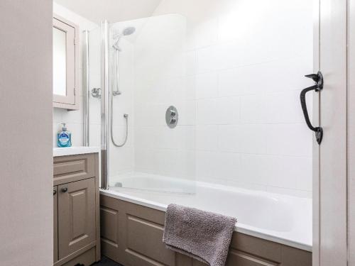 een witte badkamer met een bad en een douche bij The Old Granary in Stoke Fleming