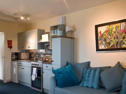 a living room with a couch and a kitchen at St Abbs The Flag House in Saint Abbs