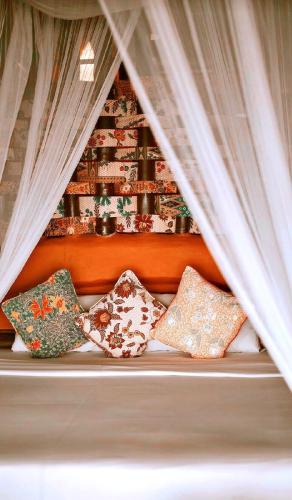 a bunch of pillows sitting on a bed with curtains at Koh Tao Cabana in Koh Tao