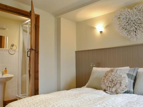 um quarto com uma cama com uma almofada em The Cottage At Wilson House em Rokeby