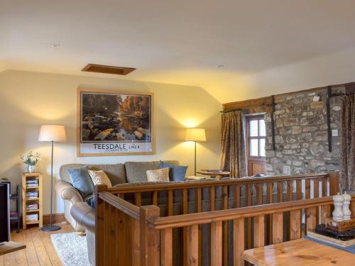 uma sala de estar com um sofá e uma parede de pedra em The Cottage At Wilson House em Rokeby