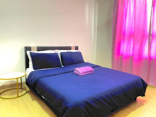 a bedroom with a blue bed with a pink pillow at Wallaway2stay Gravit8 Klang 2 Plus 1Room in Klang