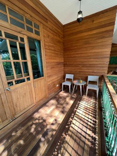 a porch with two chairs and a table on a deck at Home of Dusita in Lamphun