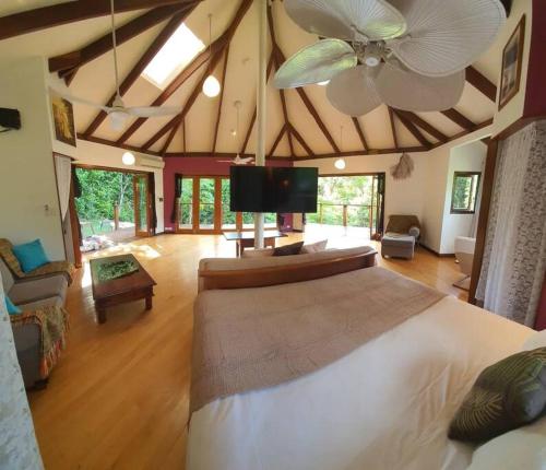 1 dormitorio con 1 cama grande y ventilador de techo en Treeverb Beach House - Daintree en Cow Bay