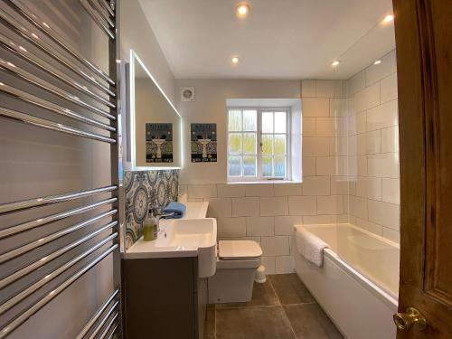 a bathroom with a sink and a tub and a toilet at The Bothy in Staple