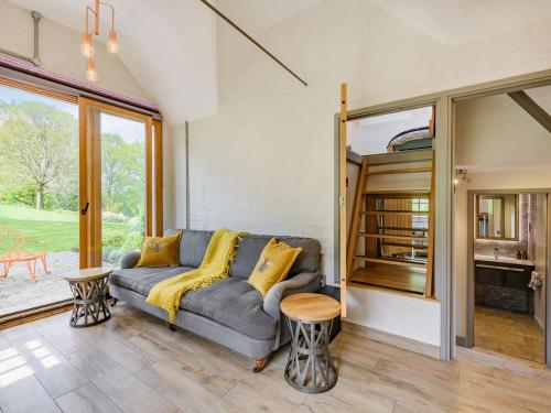 ein Wohnzimmer mit einem grauen Sofa und gelben Kissen in der Unterkunft The Cottage High Wykehurst End in Cranleigh