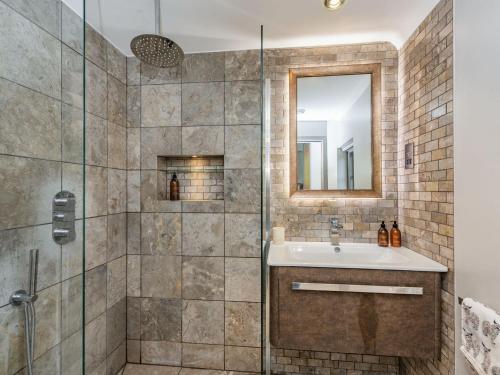 ein Bad mit einer Dusche, einem Waschbecken und einem Spiegel in der Unterkunft The Cottage High Wykehurst End in Cranleigh