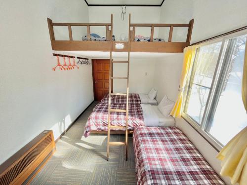 um pequeno quarto com 2 beliches em ペンションcollege白馬 em Hakuba