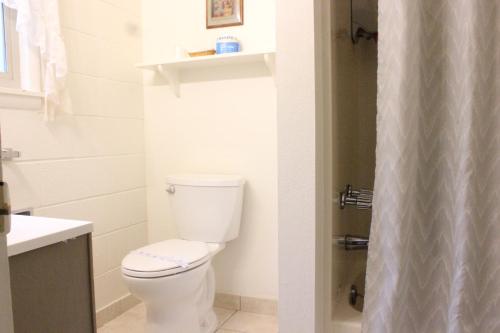 a white bathroom with a toilet and a shower at Port Townsend Inn in Port Townsend