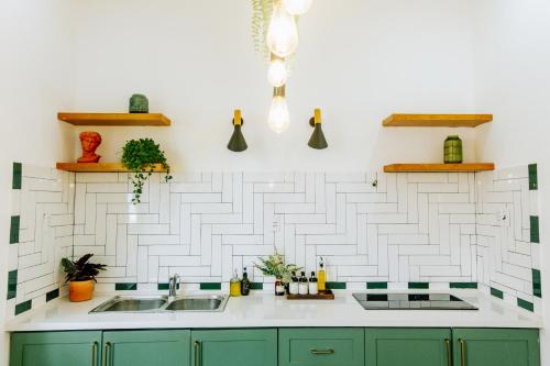 uma cozinha com armários verdes e uma parede branca em Modern Greenhouse Garden View Villa in Vung Tau em Vung Tau