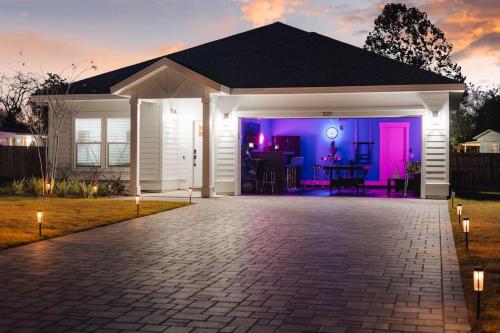 巴拿馬市海灘的住宿－Emerald-Gem-Inn • Laguna Haven/Beach Home!，院子里白色的房子,有紫色的灯