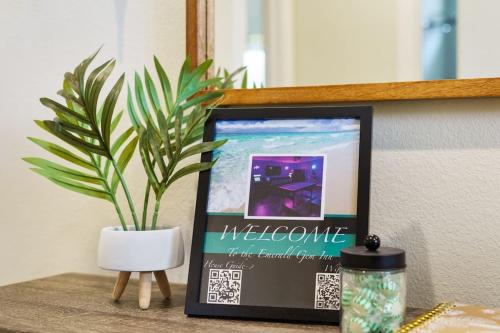 a plant sitting next to a picture frame on a table at Emerald-Gem-Inn • Laguna Haven/Beach Home! in Panama City Beach