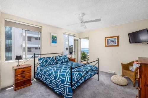 a bedroom with a bed and a tv and windows at Birdseye View Apartment at Nelson Bay in Nelson Bay
