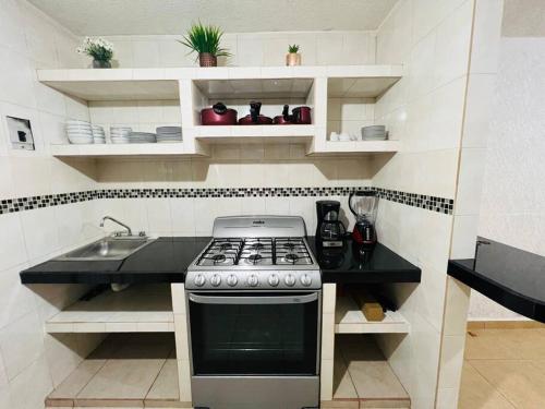 a kitchen with a stove and a sink at Casa a 7 min de playa in Ixtapa