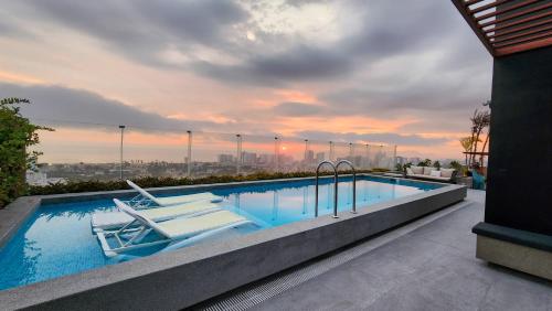 a swimming pool with two lounge chairs on top of a building at Depa acogedor en el corazón de la ciudad in Lima