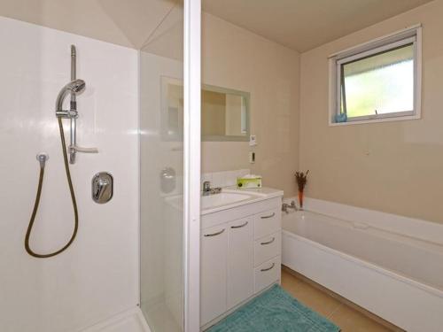 a bathroom with a shower and a sink and a tub at Family Villa in Christchurch