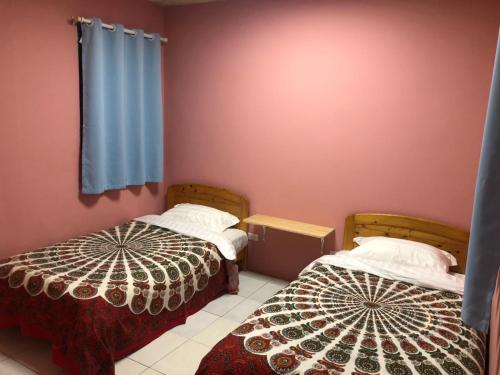 2 camas en una habitación con paredes rosas en 藏夫私廚的家, en Toucheng