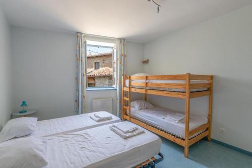 1 Schlafzimmer mit 2 Etagenbetten und einem Fenster in der Unterkunft Cabana & Le Gîte de Domange - Proche Mâcon in Igé