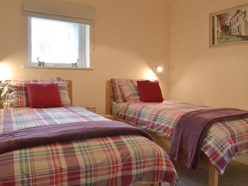 a bedroom with two beds and a window at Mendip in Cheddar