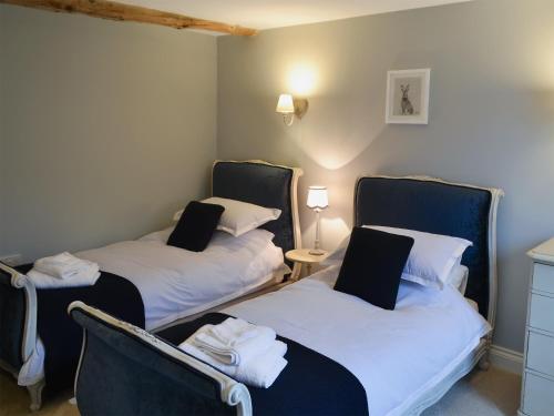 twee bedden in een kamer met twee stoelen en een tafel bij Woodcrest Barn Cottage - Ukc1065 in Shelfanger