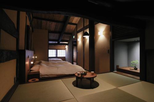 a bedroom with a bed and a table at 八百熊川 Yao-Kumagawa in Kumagawa
