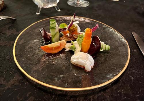 a plate of food with vegetables on a table at Château de feuilles & SPA - Praslin island in Baie Sainte Anne
