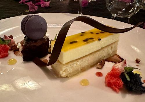 a piece of cheesecake on a white plate with chocolate at Château de feuilles & SPA - Praslin island in Baie Sainte Anne