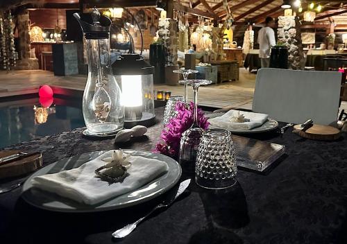 a table with plates and napkins on top of it at Château de feuilles & SPA - Praslin island in Baie Sainte Anne