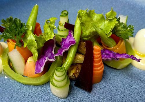 a pile of vegetables on a blue table at Château de feuilles & SPA - Praslin island in Baie Sainte Anne