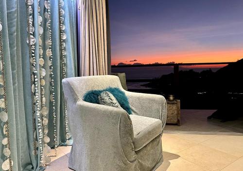 a living room with a chair and a window at Château de feuilles & SPA - Praslin island in Baie Sainte Anne