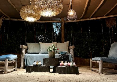 a living room with a bed and a table and chairs at Château de feuilles & SPA - Praslin island in Baie Sainte Anne