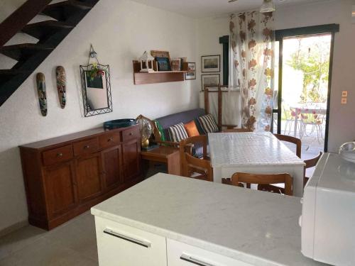 een keuken en een woonkamer met een tafel en een bank bij Holiday home in Isola Albarella 43176 in Isola Albarella