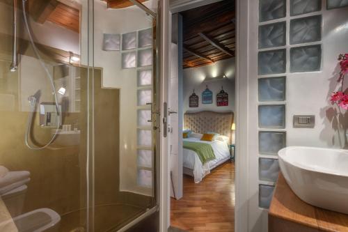a bathroom with a shower and a sink and a bed at RomEnjoy Colosseo in Rome