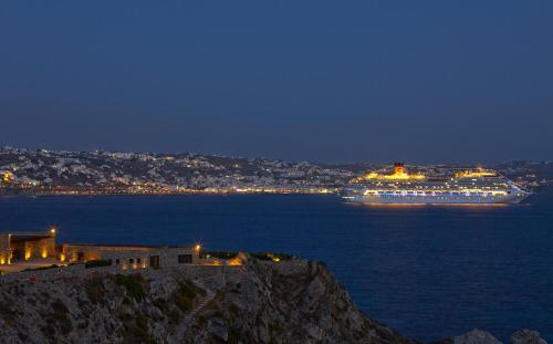 a cruise ship in the ocean at night at Rocabella Mykonos Hotel in Agios Stefanos