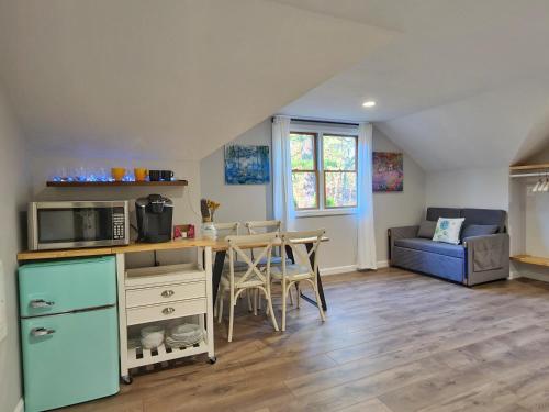 uma cozinha e sala de estar com uma mesa e um micro-ondas em Le Elona, a private island getaway experience em Peabody