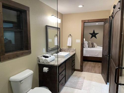 1 cama y baño con lavabo y aseo. en Bent Tree Cabin, on Private 12.5 Acres + Hot Tub, en Broken Bow