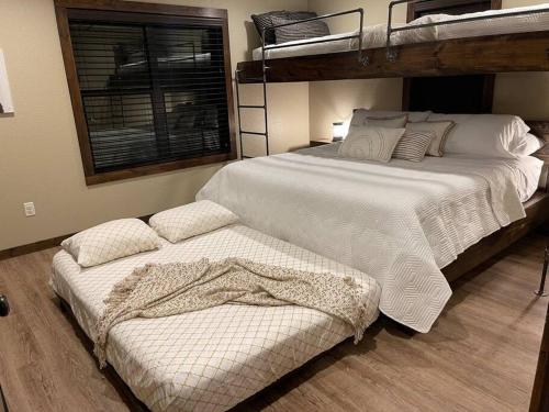 a bedroom with a large white bed and bunk beds at Bent Tree Cabin, on Private 12.5 Acres + Hot Tub in Broken Bow