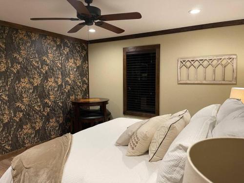 a bedroom with a bed with a ceiling fan at Bent Tree Cabin, on Private 12.5 Acres + Hot Tub in Broken Bow