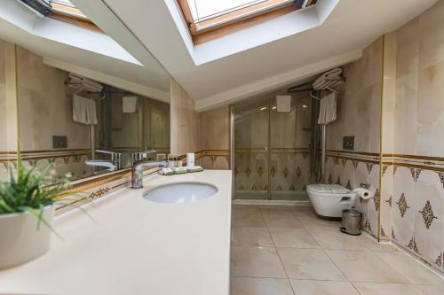 a bathroom with a sink and a toilet and a skylight at Eurostars Hotel Old City in Istanbul