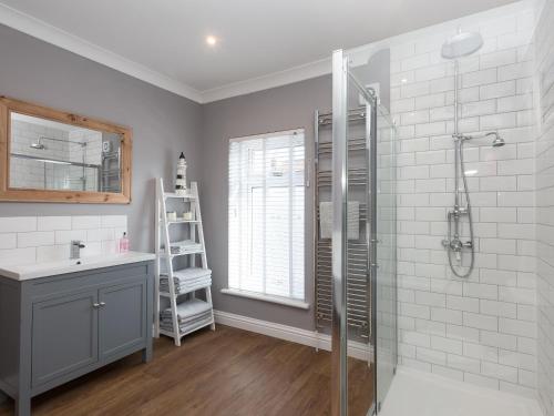 uma casa de banho com um chuveiro e um lavatório. em Amelia House em Sheringham