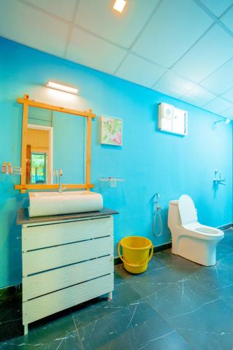 a blue bathroom with a sink and a toilet at orange sky beach bungalow in Agonda