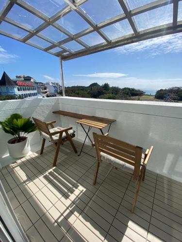 a patio with a bench and a table on a roof at Kenting Little House in Kenting