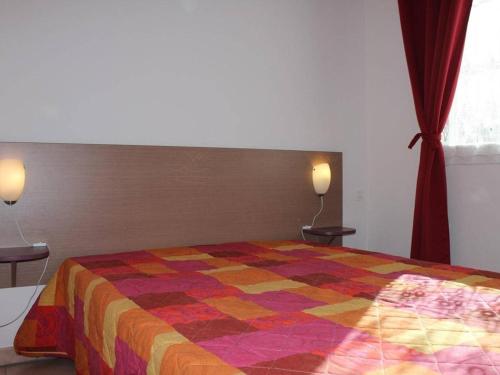 une chambre avec un lit avec une couette colorée dans l'établissement Appart T2 Piscine Clim Parking - Gruissan - FR-1-229-548, à Gruissan