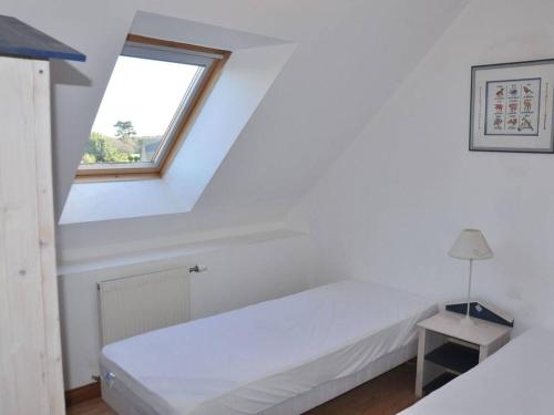 a white bedroom with a bed and a window at Maison Trébeurden, 3 pièces, 6 personnes - FR-1-368-4 in Trébeurden