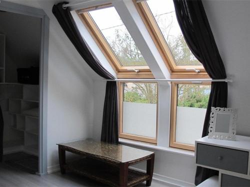 Cette chambre dispose de 2 grandes fenêtres et d'une table. dans l'établissement Maison à Ploumanac'h avec WIFI, proche du port, jardin, barbecue, garage, chiens acceptés - FR-1-368-44, à Perros-Guirec