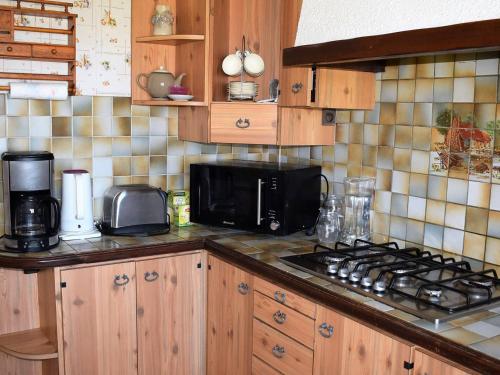 a kitchen with a stove top and a microwave at Maison avec jardin clos à louer à Louannec, à proximité de la mer - FR-1-368-65 in Louannec